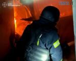 вогнеборець гасить пожежу на Житомирщині, яка виникла в результаті атаки російських терористів